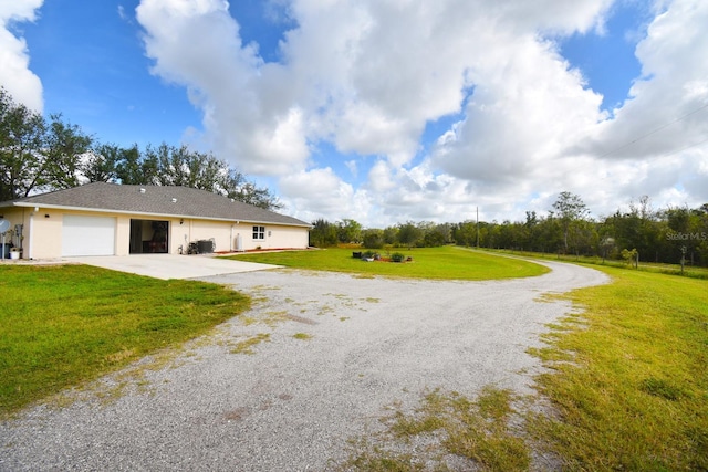 31730 Clay Gully Rd, Myakka City, FL 34251 - rear view of property featuring driveway, a garage, a lawn, and stucco siding