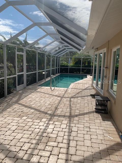 view of swimming pool featuring a patio area and a lanai