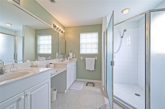 bathroom featuring tile patterned floors, plenty of natural light, walk in shower, and vanity