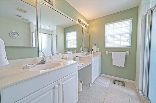 bathroom featuring tile patterned flooring, vanity, walk in shower, and a wealth of natural light