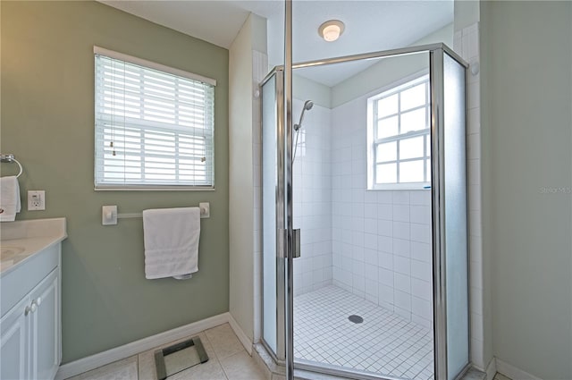 bathroom featuring vanity, tile patterned floors, plenty of natural light, and a shower with shower door