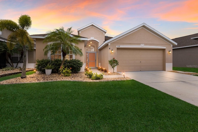 view of front of home featuring concrete driveway, a garage, a front yard, and stucco siding