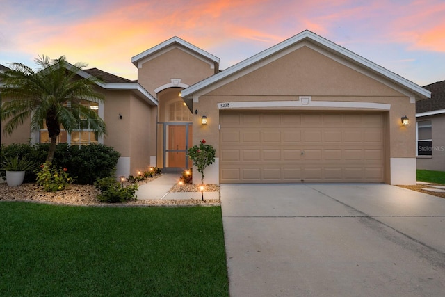 ranch-style home with a yard and a garage