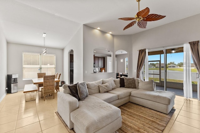 living room featuring light tile patterned floors, a towering ceiling, and ceiling fan