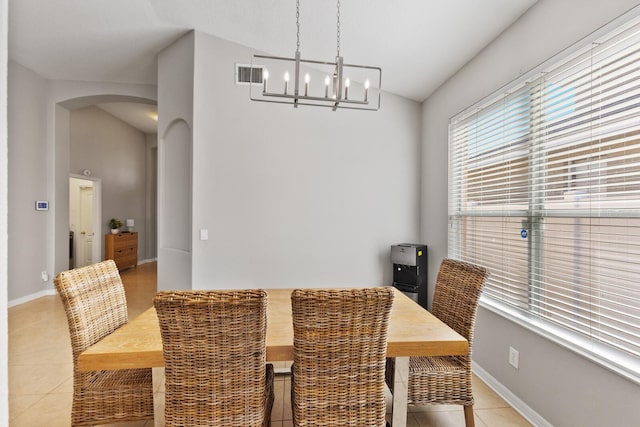 dining area featuring vaulted ceiling, a notable chandelier, and light tile patterned flooring