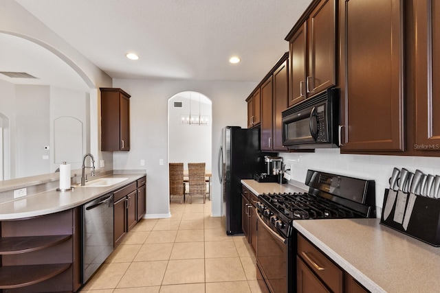 kitchen with dark brown cabinetry, sink, light tile patterned flooring, and black appliances