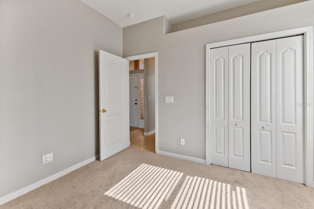 unfurnished bedroom featuring light colored carpet and a closet