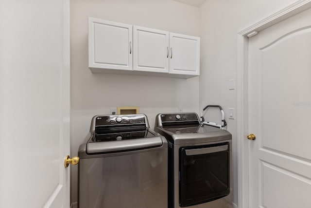 laundry area featuring washer and clothes dryer and cabinets