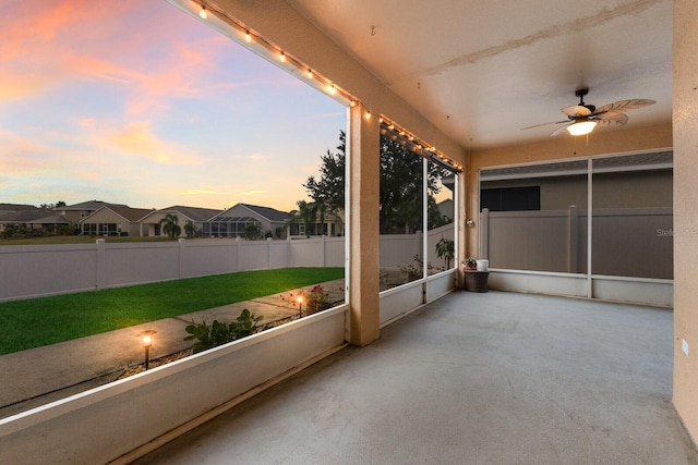 unfurnished sunroom with ceiling fan