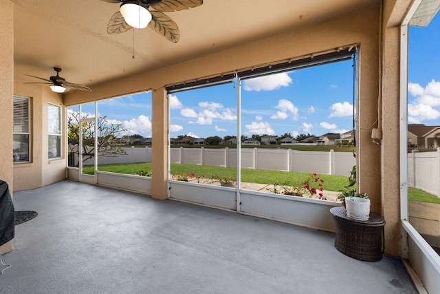 unfurnished sunroom with ceiling fan