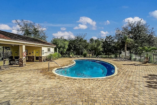 view of swimming pool featuring ceiling fan and a patio