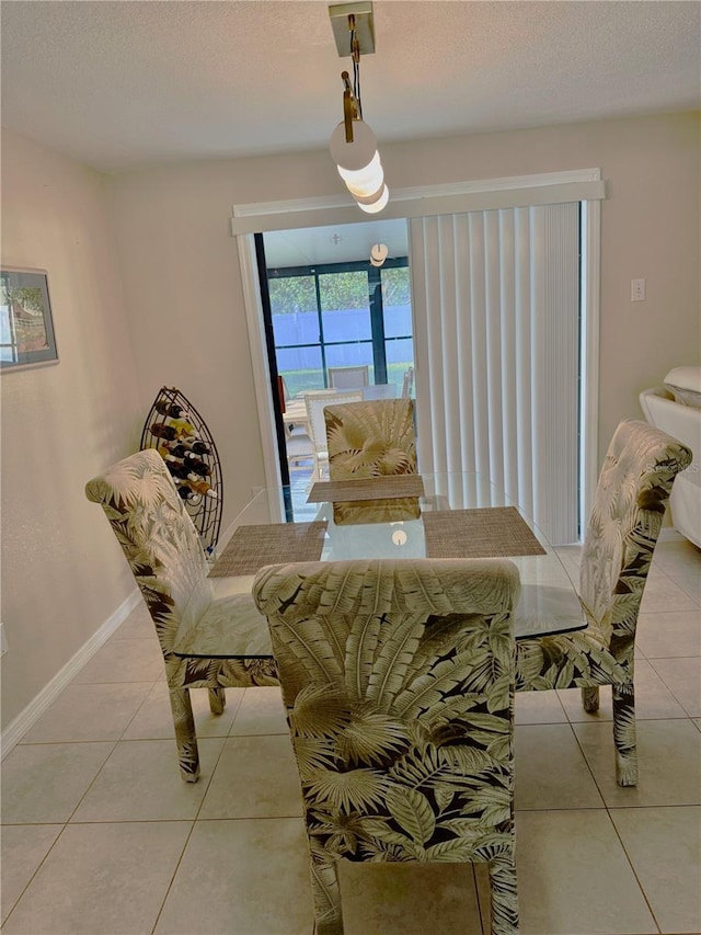 dining area with a textured ceiling and tile patterned floors