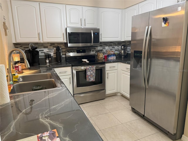 kitchen featuring decorative backsplash, stainless steel appliances, white cabinetry, and sink