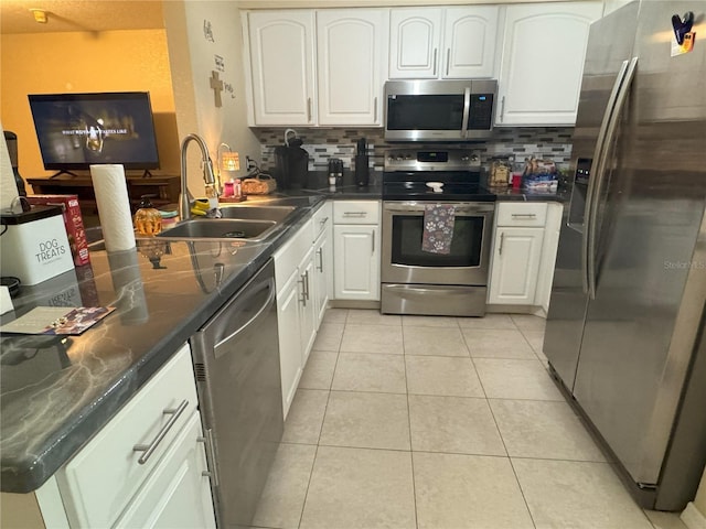 kitchen featuring backsplash, stainless steel appliances, sink, white cabinets, and light tile patterned flooring