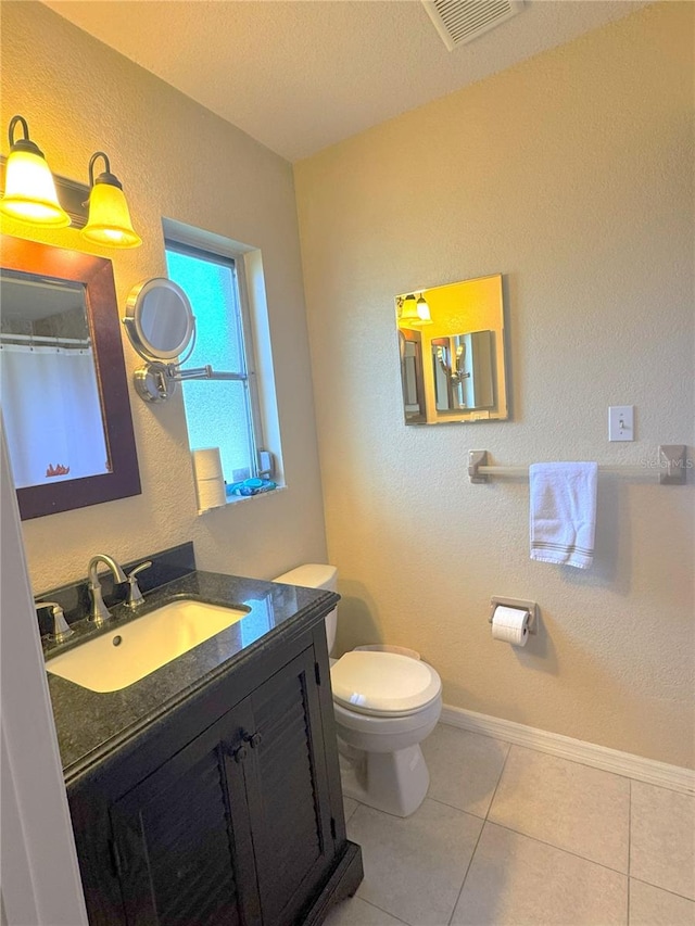 bathroom featuring tile patterned flooring, vanity, and toilet