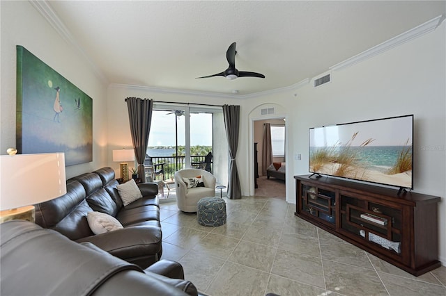 living room featuring light tile patterned floors, ceiling fan, and crown molding