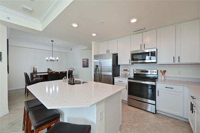 kitchen with a kitchen island with sink, sink, ornamental molding, appliances with stainless steel finishes, and white cabinetry