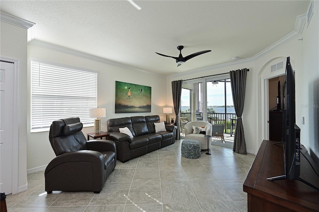 living room featuring ceiling fan, crown molding, and a healthy amount of sunlight