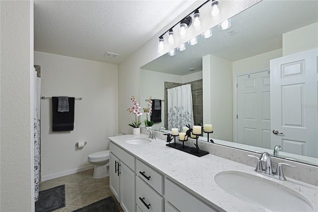 bathroom with vanity, tile patterned floors, toilet, a textured ceiling, and walk in shower