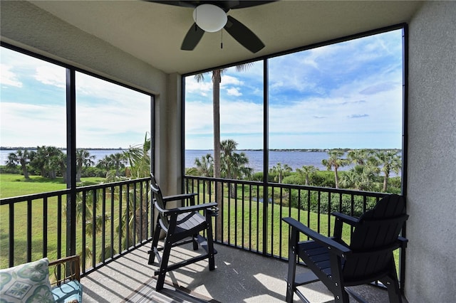 sunroom / solarium with a water view and ceiling fan