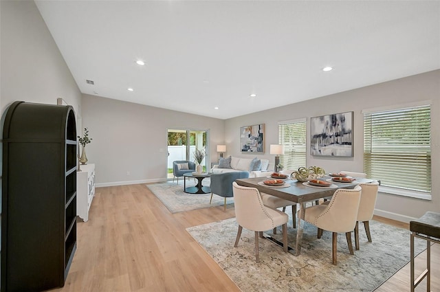 dining area featuring light hardwood / wood-style floors and vaulted ceiling