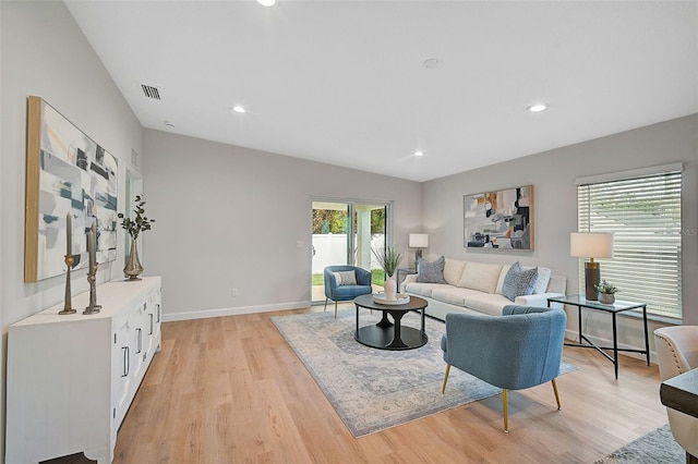 living room featuring light wood-type flooring and vaulted ceiling