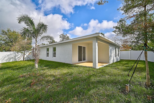 rear view of property featuring a yard and a patio