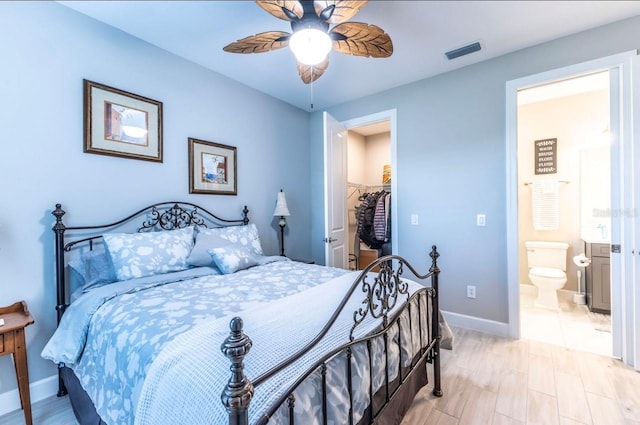 bedroom featuring a walk in closet, ensuite bath, a closet, and ceiling fan