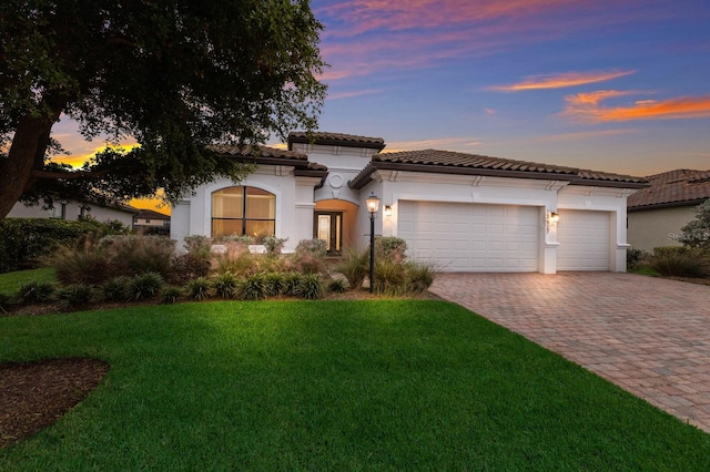 13627 American Prairie Pl, Lakewood Ranch, FL 34211 - mediterranean / spanish house featuring decorative driveway, stucco siding, an attached garage, a front yard, and a tile roof