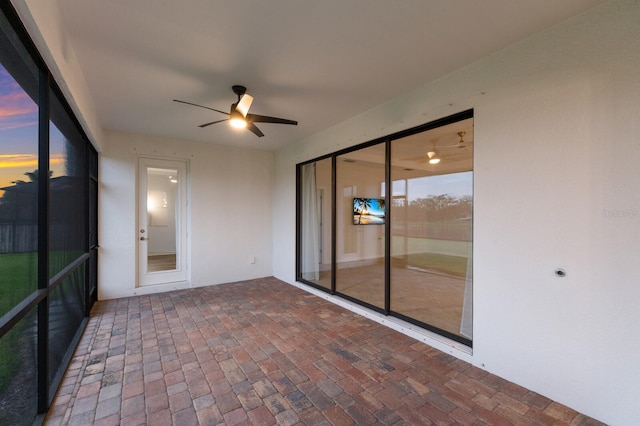 unfurnished sunroom with ceiling fan