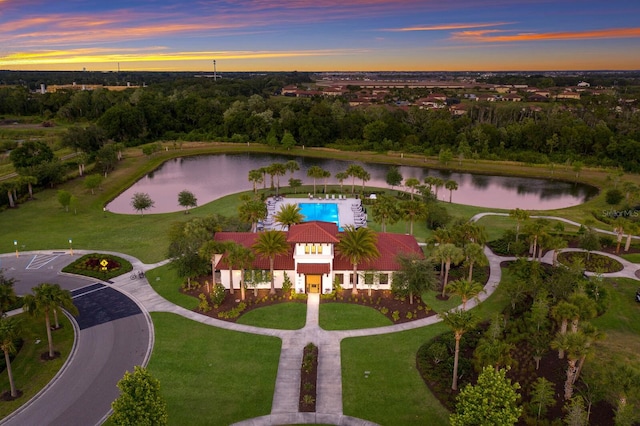 aerial view at dusk featuring a water view