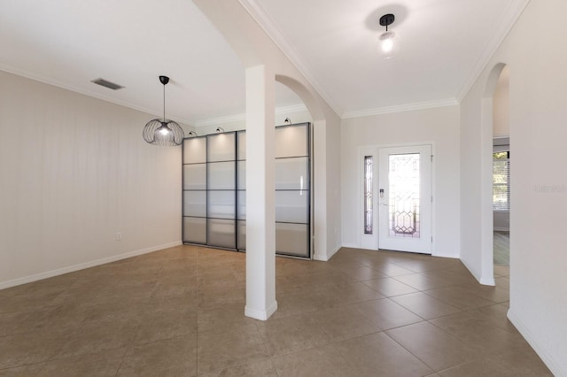 foyer entrance with tile patterned floors and ornamental molding