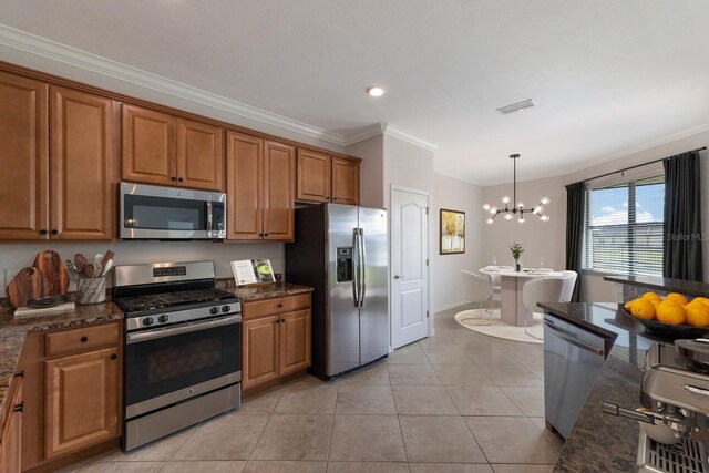 13627 American Prairie Pl, Lakewood Ranch, FL 34211 - kitchen with appliances with stainless steel finishes, crown molding, brown cabinetry, a chandelier, and light tile patterned floors