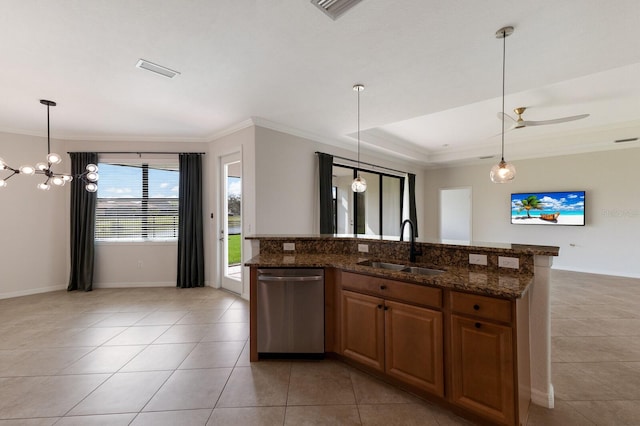 kitchen with dark stone counters, dishwasher, pendant lighting, and sink