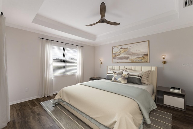 13627 American Prairie Pl, Lakewood Ranch, FL 34211 - bedroom with a tray ceiling, wood finished floors, ornamental molding, a ceiling fan, and baseboards