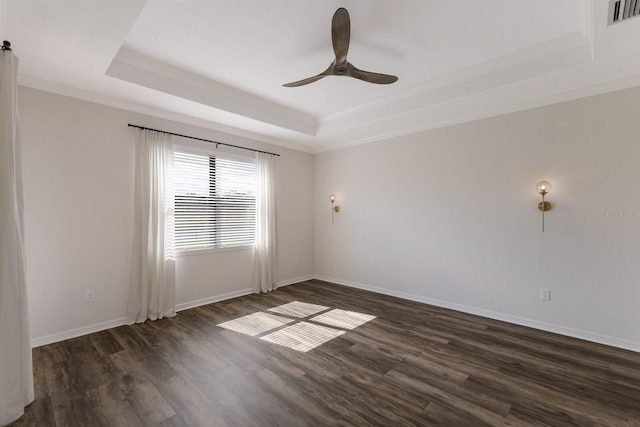 13627 American Prairie Pl, Lakewood Ranch, FL 34211 - spare room featuring a raised ceiling, dark wood finished floors, a ceiling fan, ornamental molding, and baseboards