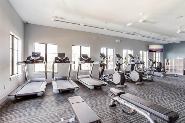 exercise room with dark colored carpet and ceiling fan