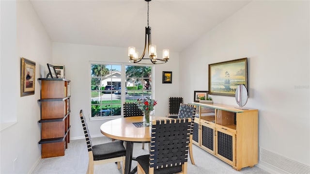 dining room featuring a notable chandelier, light colored carpet, and vaulted ceiling