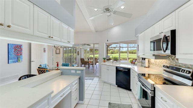 kitchen with white cabinets, stainless steel appliances, and beamed ceiling