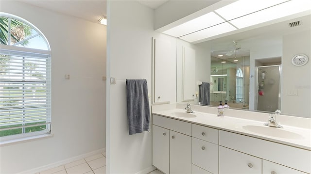 bathroom with tile patterned flooring, ceiling fan, a shower with shower door, and vanity