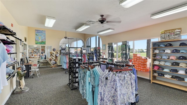 exercise room featuring dark carpet and ceiling fan