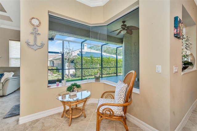 interior space with ceiling fan and ornamental molding