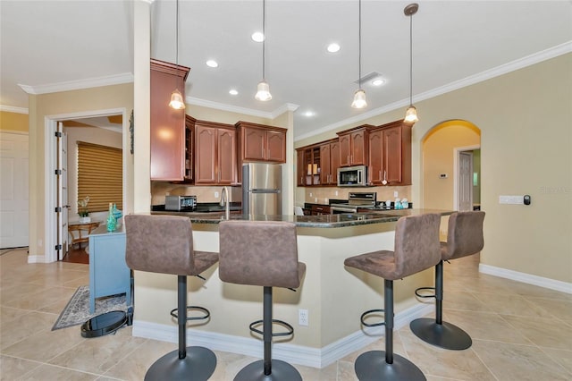 kitchen featuring pendant lighting, a breakfast bar, ornamental molding, and appliances with stainless steel finishes