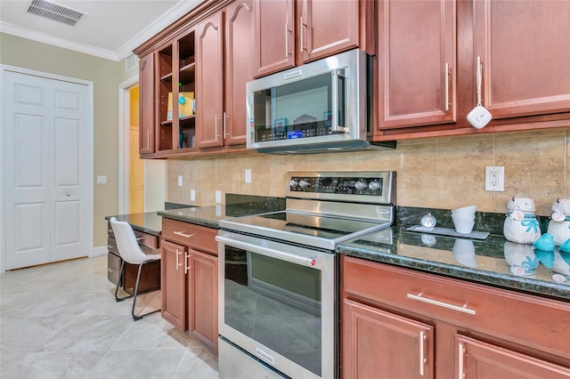 kitchen featuring dark stone countertops, decorative backsplash, light tile patterned flooring, and appliances with stainless steel finishes