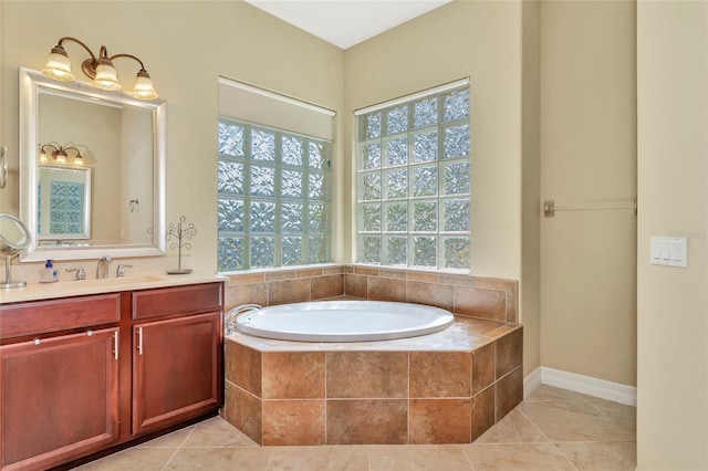 bathroom with tile patterned flooring, a relaxing tiled tub, and vanity