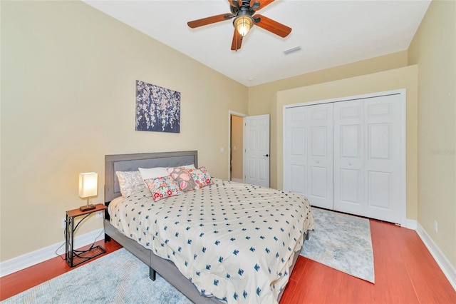 bedroom with hardwood / wood-style floors, ceiling fan, and a closet