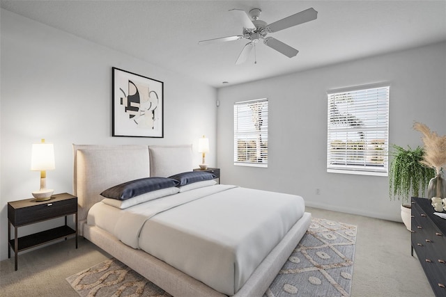 carpeted bedroom featuring multiple windows and ceiling fan