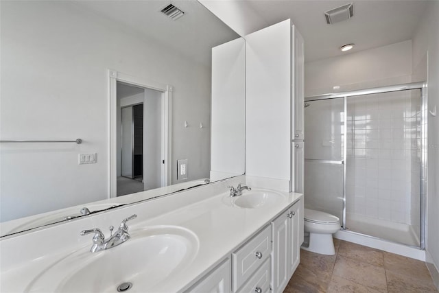 bathroom featuring a shower with door, vanity, and toilet