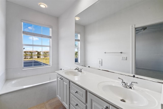 bathroom featuring a bathing tub, ceiling fan, tile patterned flooring, and vanity