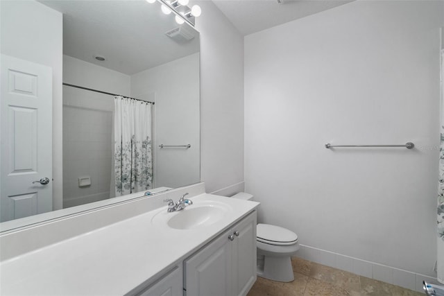 bathroom featuring a shower with shower curtain, a textured ceiling, vanity, and toilet